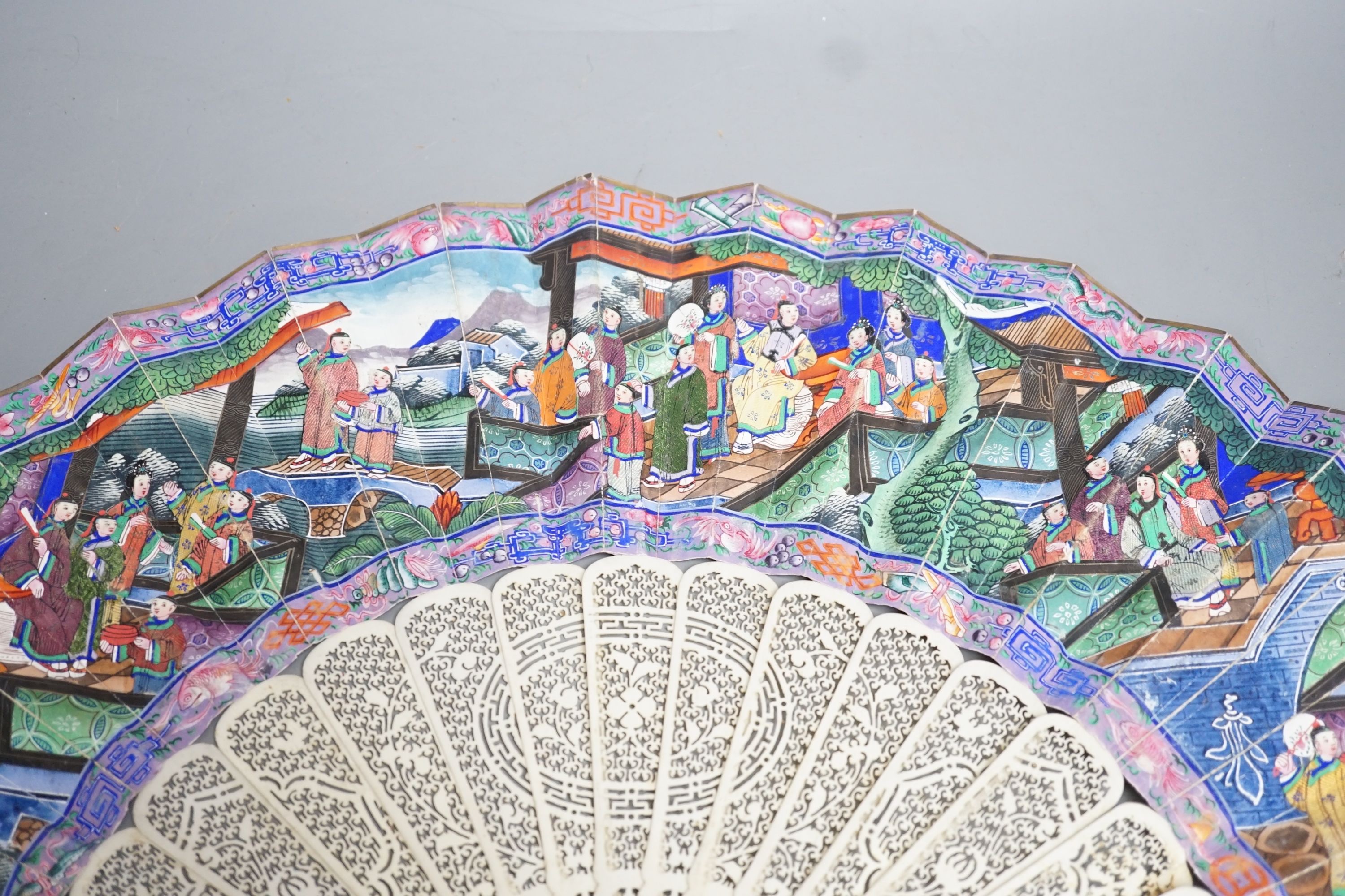 A 19th century Chinese export pierced ivory and painted paper leaf fan. 28cm long